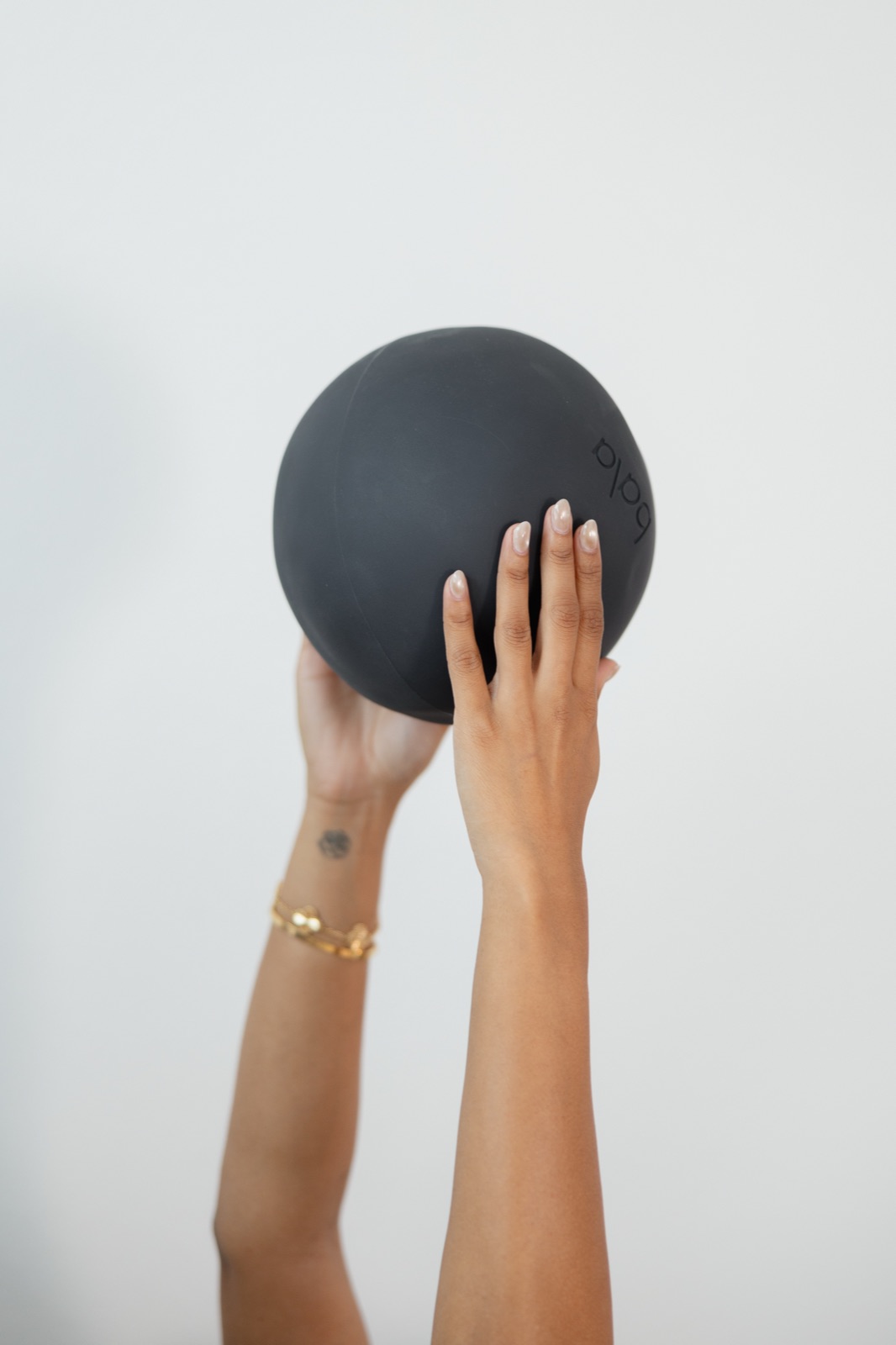 Woman holding a soft blue exercise ball in a bright studio
